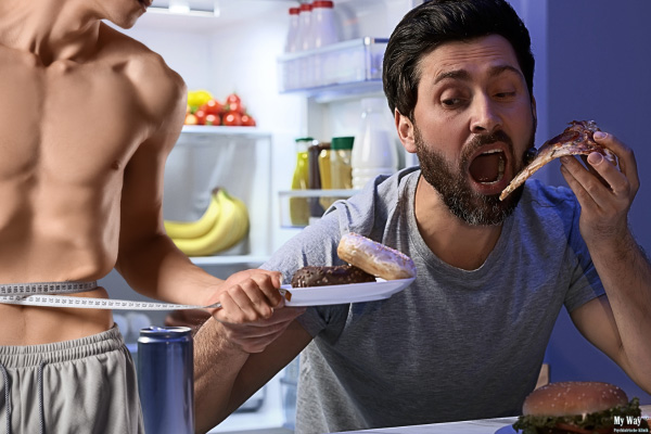Ein Mann isst nachts vor offenem Kühlschrank unkontrolliert Pizza und Donuts, während ein abgemagerter Oberkörper neben ihm steht und Essstörungen bei Männern symbolisiert