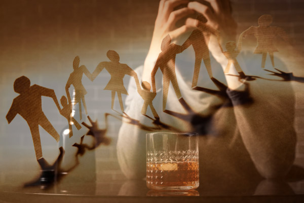 Gestresste Person mit einem Glas Alkohol, im Vordergrund Papierfiguren als Darstellung familiärer Belastung und als Symbolbild für Sucht in der Familie