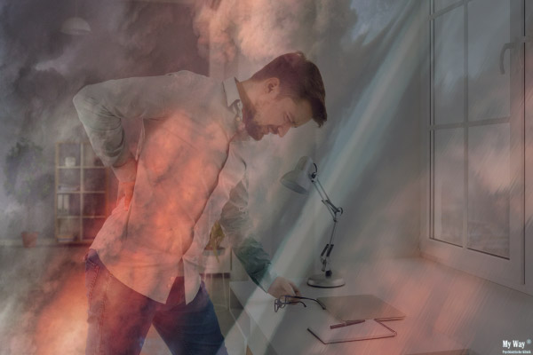 Ein Mann steht gebeugt an einem Tisch und hält sich den Rücken, ein roter Nebel liegt auf seinem Körper