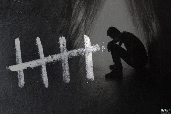 Silhouette einer zusammengesunkenen Person in dunkler Umgebung, daneben Strichmarkierungen als Symbol für die fünf Phasen des schleichenden Verlaufs einer Sucht]