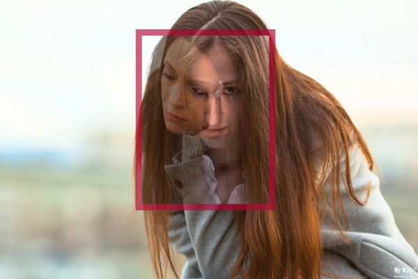 Eine junge Frau mit zwei Gesichtern, eines schaut traurig, das andere blickt direkt in die Kamera